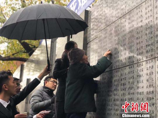 夏淑琴老人用手撫摸著親人的名字?！≈鞎苑f 攝