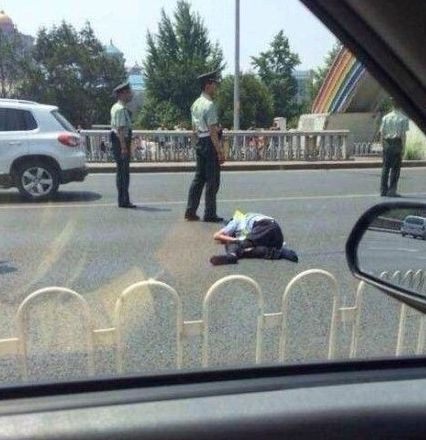 交警被撞出大概10米左右，趴在地上一動(dòng)不動(dòng)。