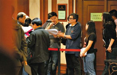 12日，北京麗都飯店，馬航工作人員叫乘客家屬進(jìn)屋領(lǐng)取慰問金。目前，馬航兩次向乘客家屬發(fā)放慰問金，但未啟動(dòng)賠償。新京報(bào)記者